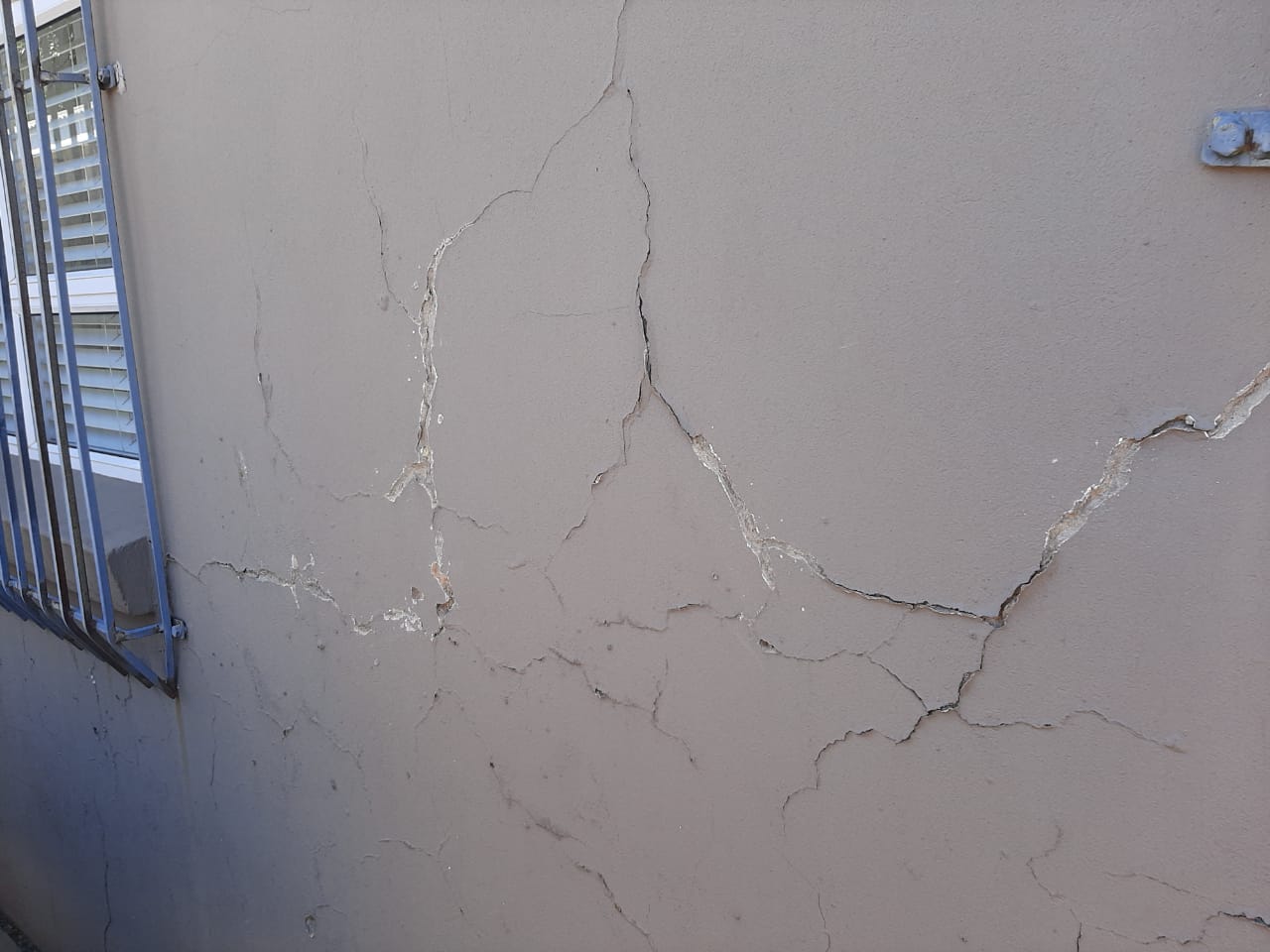 Wide view of a wall with extensive plaster damage